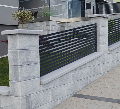Zaunmauer als Einfriedung in hellgrau mit leichten Streifen aus Beton und dunkelgrauem Aluzaun von BK