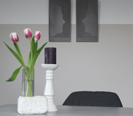 Tisch mit Tischplatte aus Beton, Betonbild mit Gesicht in Grau, Kerzenständer und Vase in Weiß von BK
