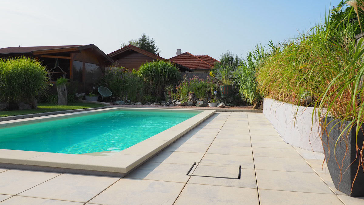 Garten mit Poolumrandung in Beige marmoriert und quadratischen Terrassenplatten von BK